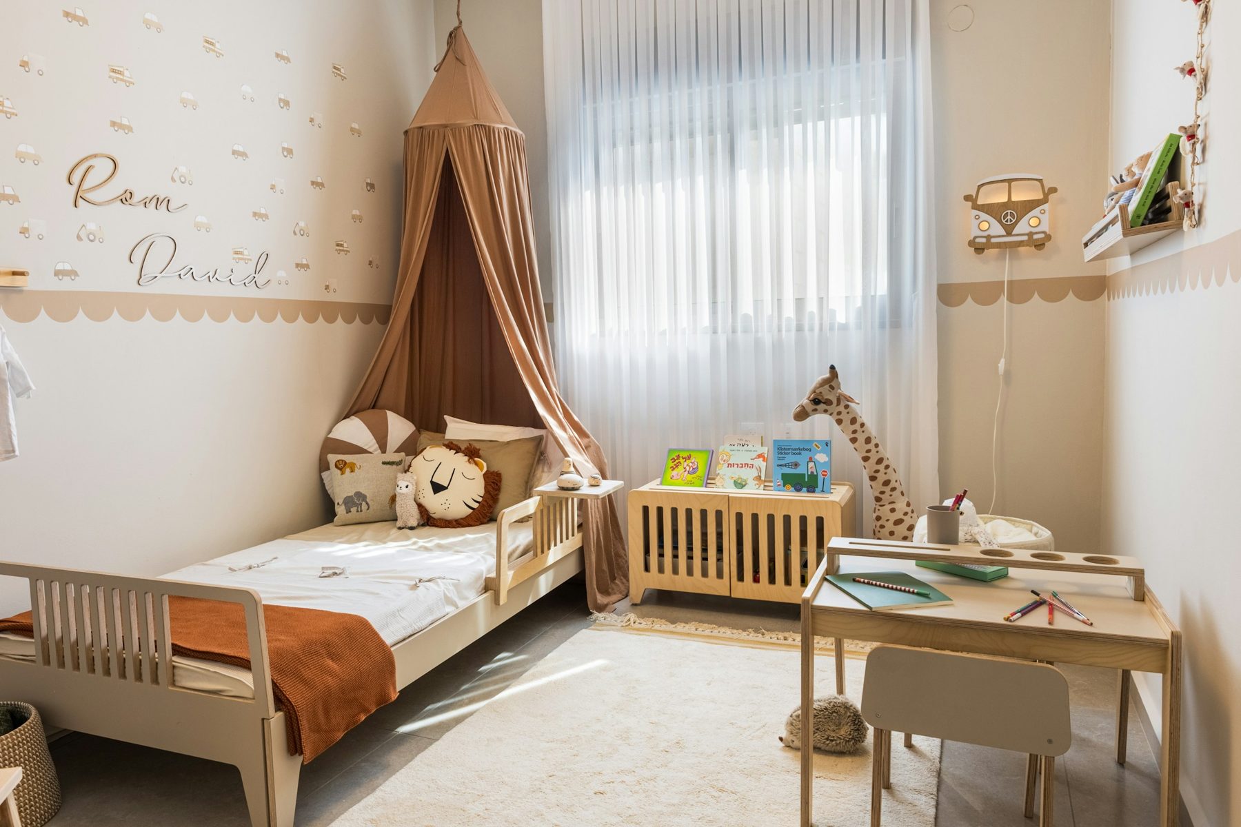 Ein helles Kinderzimmer mit Bett, Schreibtisch und Fenster